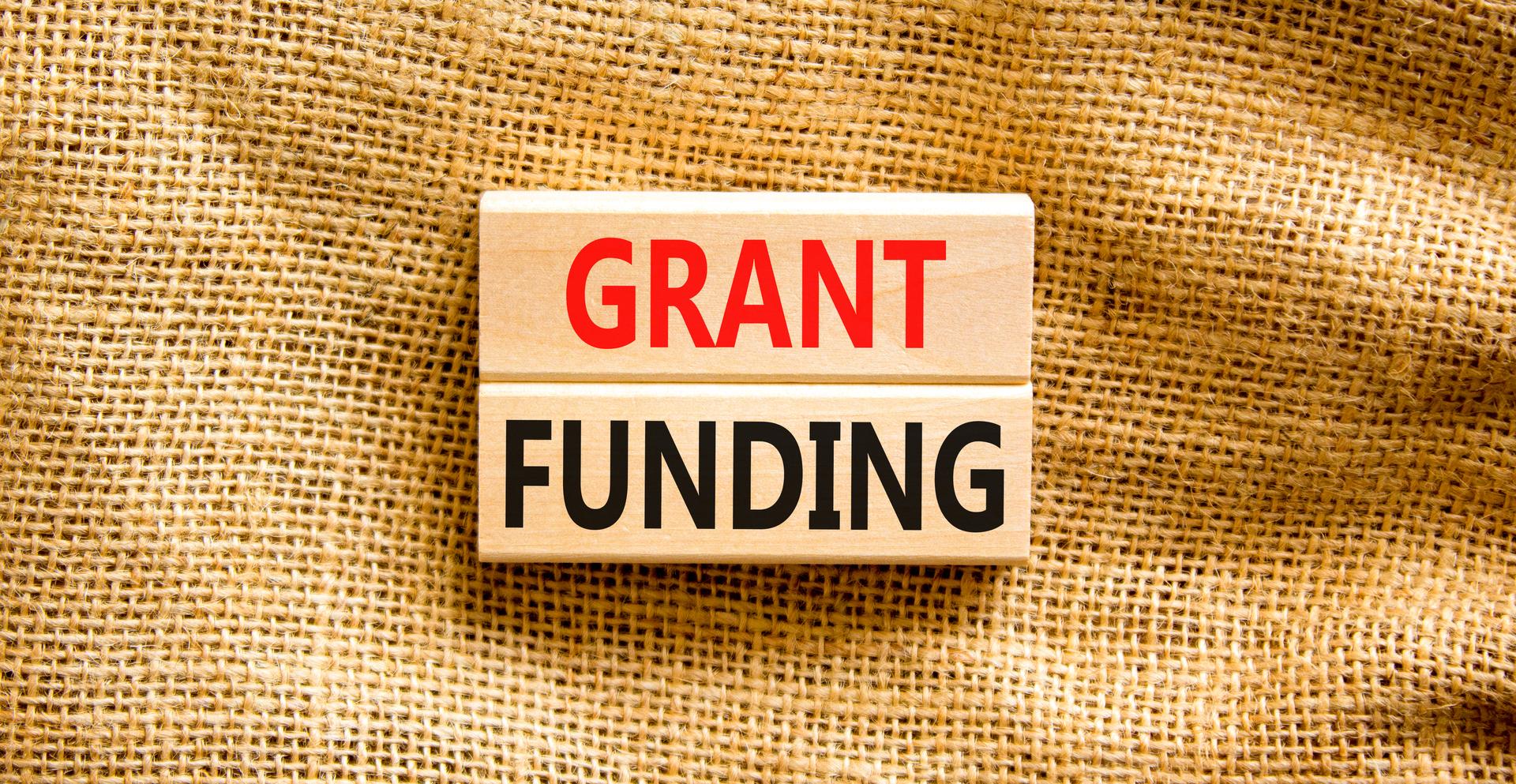 Grant funding symbol. Concept words Grant funding on wooden blocks. Beautiful canvas table canvas background. Business and grant funding concept. Copy space.