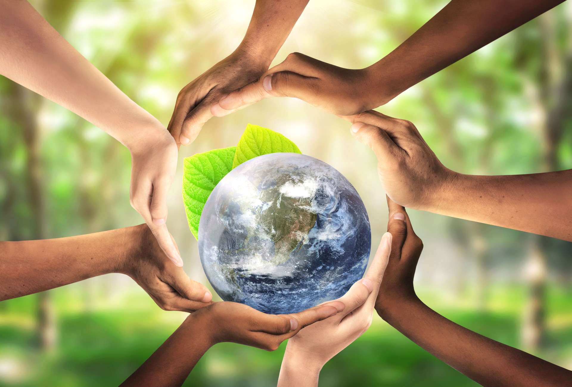 Conceptual symbol of multiracial human hands surrounding the Earth globe. Unity, world peace, humanity concept. World environment day- Earth Day concept. Elements of this image furnished by NASA.